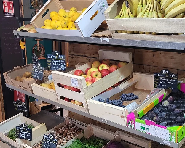 Des pommes, raisons, poires, champignons, haricots verts, citrons et bananes en vrac séparés dans des cageots en bois