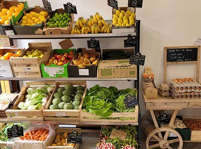 Plusieurs fruits et légumes en vrac dans des cageots entreprosés sur une étagère en magasin