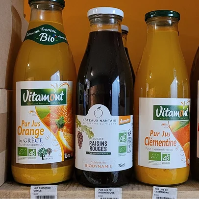 Une bouteille de jus d'orange, une bouteille de jus de raisin et une bouteille de clémentine
